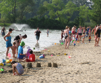 children and adults at the shore of the reservation swimming area